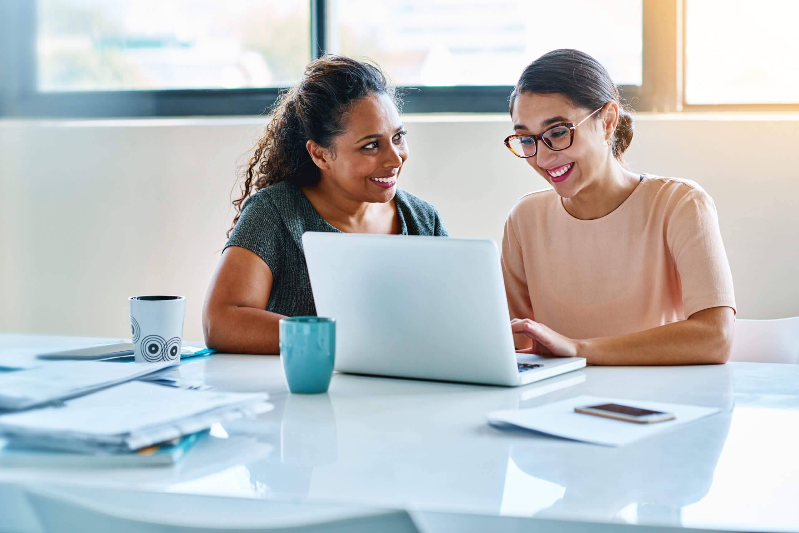 Two women at work looking at a laptop